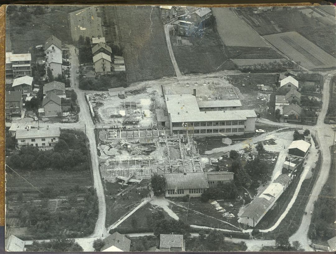 Gradilište novog krila škole, u dnu slike je stara zgrada, a lijevo od nje avion. Snimljeno 1977. [FB 2025.]